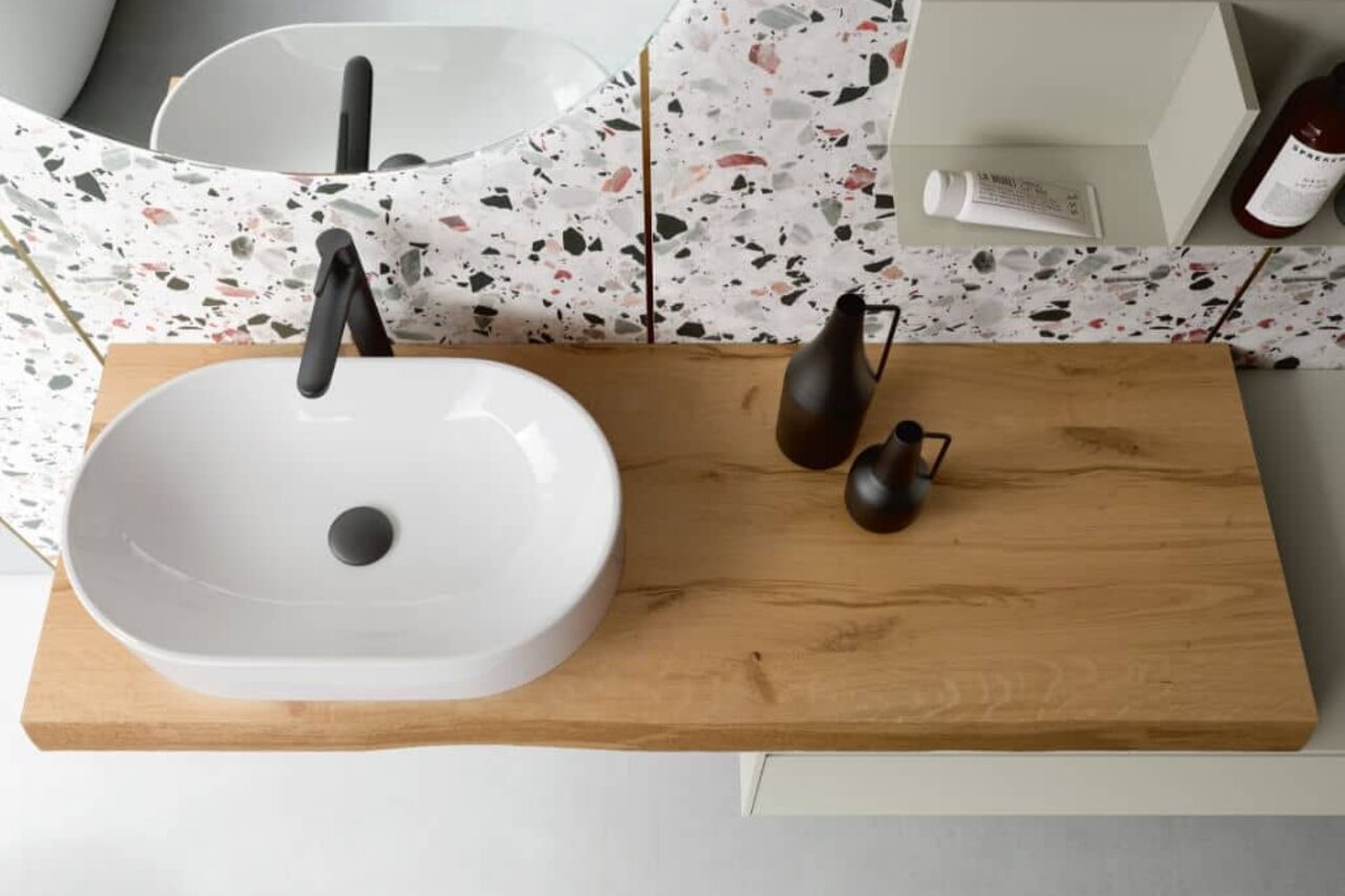 Lavabo in appoggio su piano in legno con specchio e rubinetteria scura