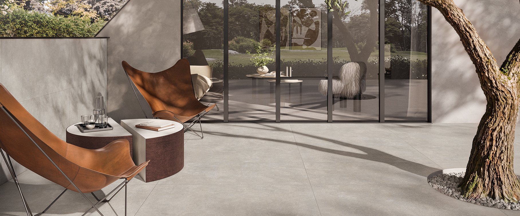 Terrazza con pavimento in gres porcellanato da esterno e vetrata sul giardino
