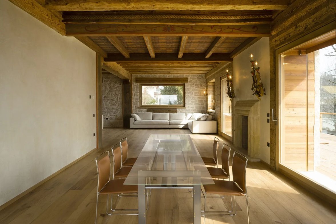 Sala da pranzo con parquet in legno e travi a vista
