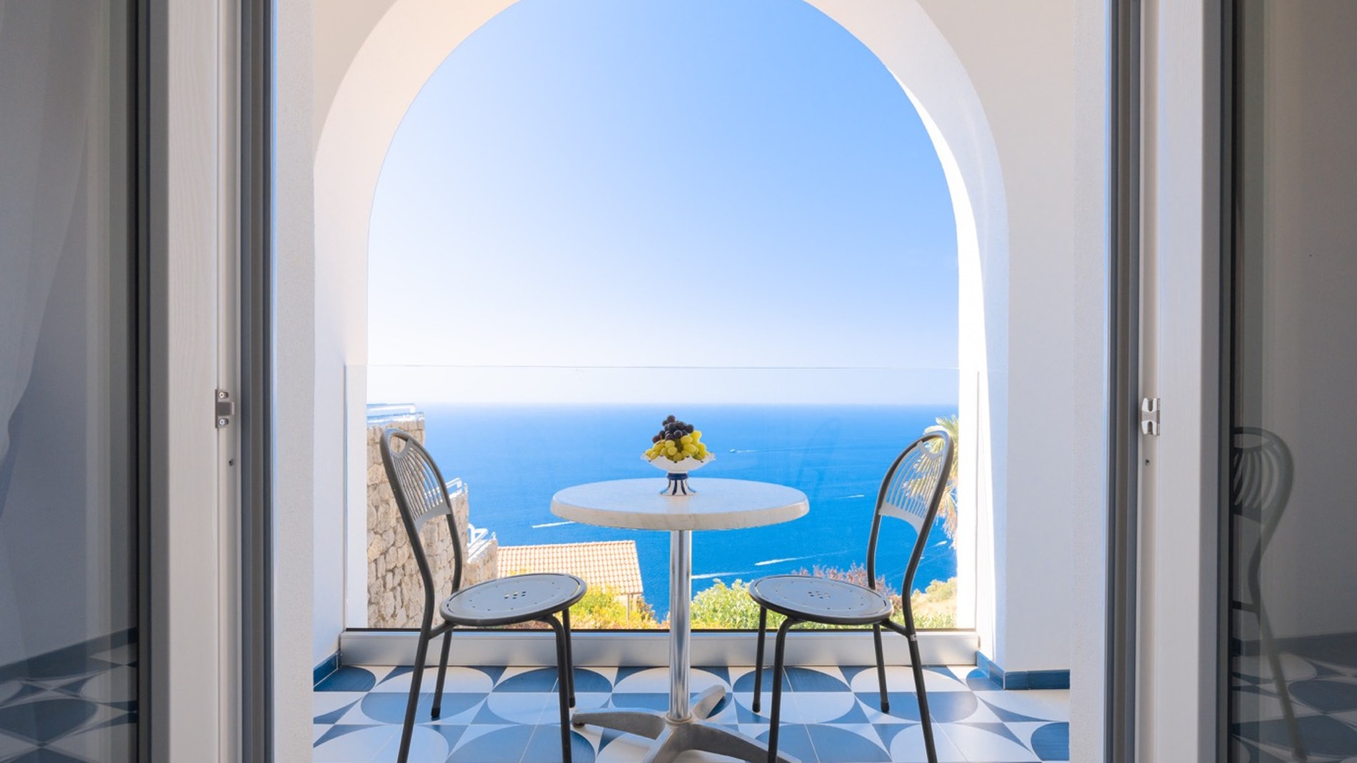 Vetrata panoramica affacciata su panorama costiero e luce mediterranea