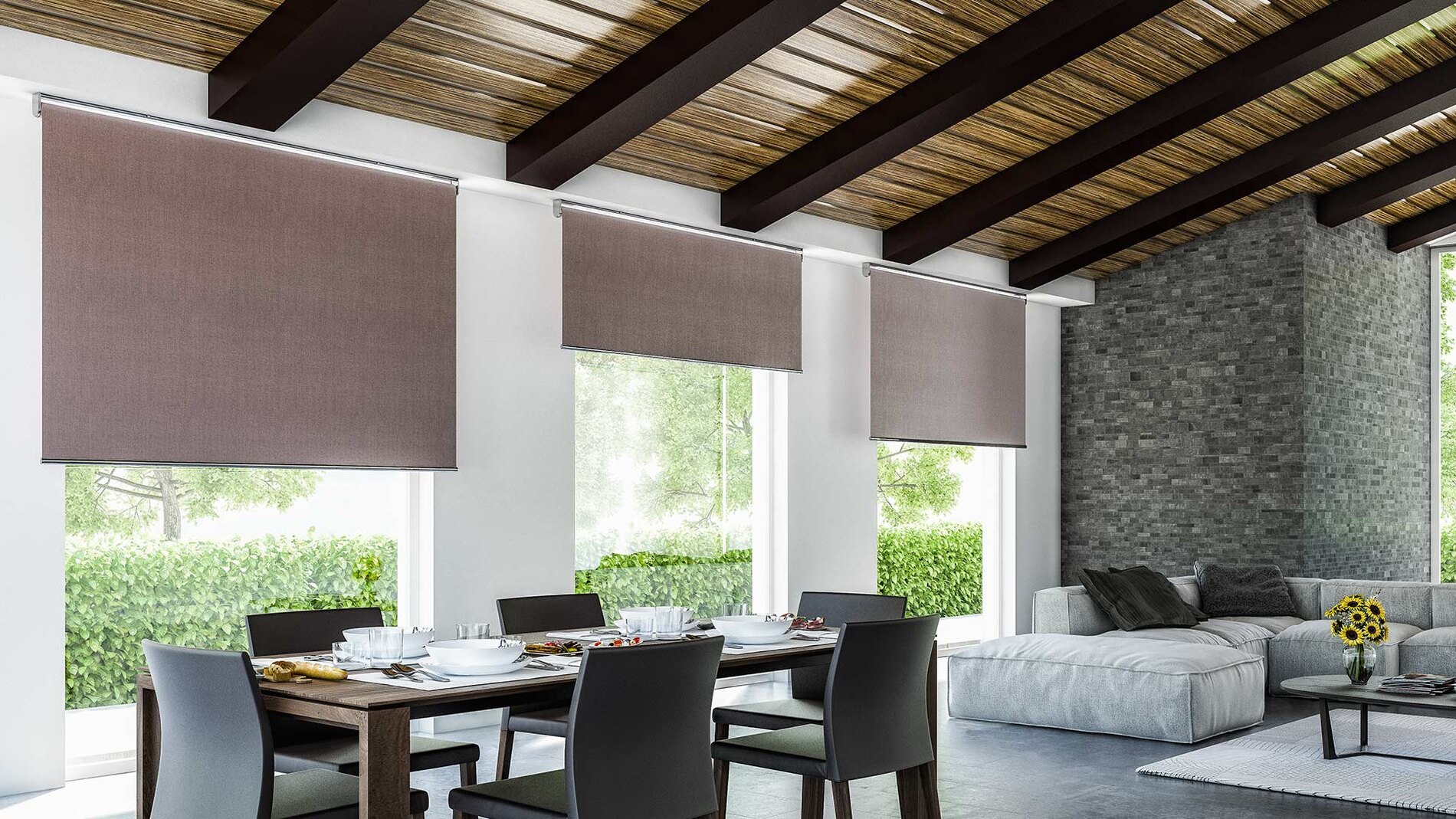 Tende tecniche a rullo abbassate sulle vetrate di un ambiente living luminoso