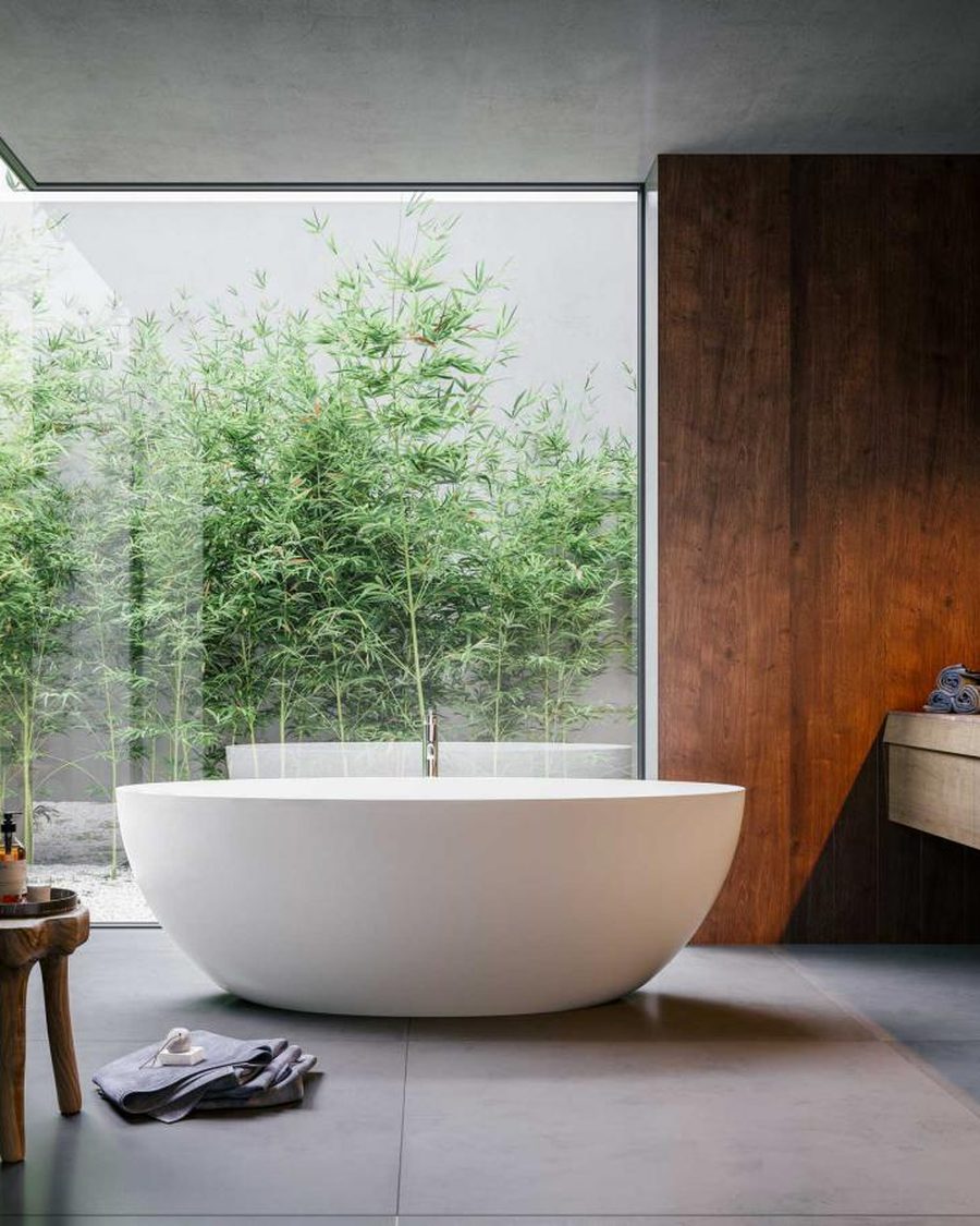 Vasca freestanding al centro di un bagno con grande vetrata